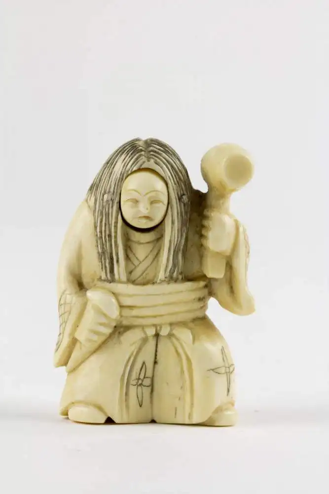 Netsuke, Japan, Meiji Zeit, Elfenbein, geschnitzte Figur mit Hammer, Daikoku einer, der 7 Glücksgötter, mit Wechselgesicht für gut und böse, Gebrauchsspuren. H: 4,8 cm. 1