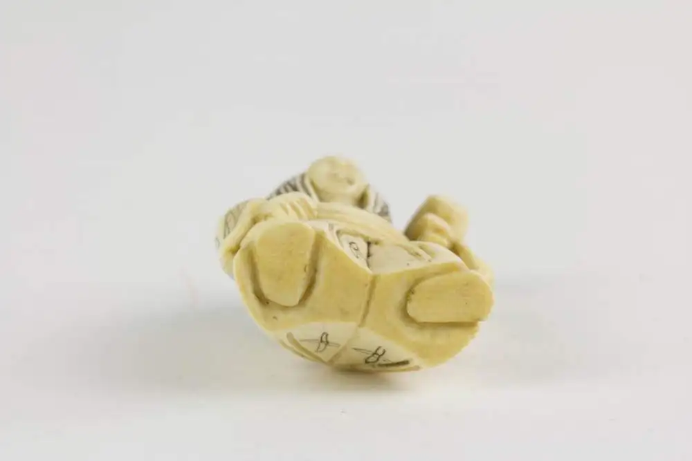 Netsuke, Japan, Meiji Zeit, Elfenbein, geschnitzte Figur mit Hammer, Daikoku einer, der 7 Glücksgötter, mit Wechselgesicht für gut und böse, Gebrauchsspuren. H: 4,8 cm. 3