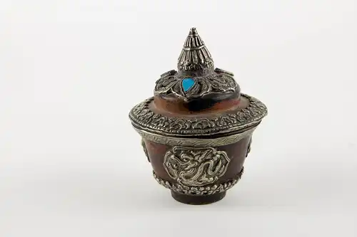 Teeschale, mit Deckel und Ständer, Tibet, 20. Jh., gedrechselte Holzkörper, reichlich mit Weißmetall und Türkisen verziert, Gebrauchsspuren. 

Teapot with cover, Tibet, 20th century, wood, decorated with metal and Turkey stone.
