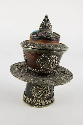 Teeschale, mit Deckel und Ständer, Tibet, 20. Jh., gedrechselte Holzkörper, reichlich mit Weißmetall und Türkisen verziert, Gebrauchsspuren. 

Teapot with cover, Tibet, 20th century, wood, decorated with metal and Turkey stone.