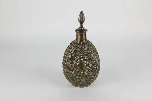Karaffe, China, (wohl Hongkong) um 1900, netzartig mit versilberten Kupferdraht überzogene Glasflasche, verziert mit buddhistischen Symbolen, berieben, Gebrauchsspuren. H: 28 cm.