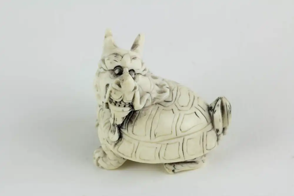 Figur, China, 19./20. Jh., Bixie (eine Figur der chinesischen Mythologie, ein Wesen mit dem Körper einer Schildkröte und dem Kopf eines Drachen), Elfenbein, geschnitzt und geschwärzt. L: 4 cm. 0