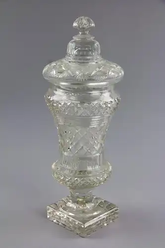 Deckelpokal, erste Hälfte 19. Jh, Glas geschliffen, kelchförmige Kuppa auf quadratischen Sockel, mit Deckel, unbeschädigt. H: 35 cm.
