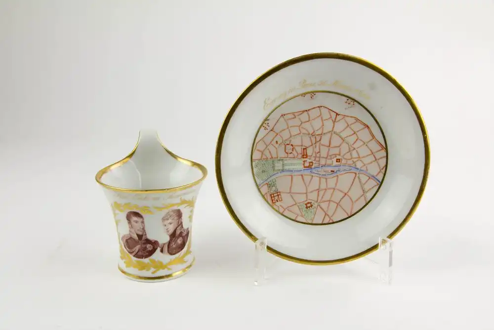 Tasse und Untertasse, gemarkt KPM, 1814, Kalathos-Form, bemalt und Umdruckdekor, auf Schauseite Portrait von König Friedrich Wilhelm III und Zar Alexander I, umgeben von Lorbeerkranz in Gold, Umschrift: Heil Euch im Siegerkranz, Untertasse mit... 1