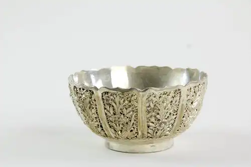 Zierschale, China, erste Hälfte 20. Jh., Silberbronze versilbert, in umlaufenden Kartuschen plastisch aufgelegte Vögel und Blumen, geschwungener Rand, kurzer Standring, feine Qualität, Gebrauchsspuren, fleckig. D: 12,5 cm, H: 6,5 cm.