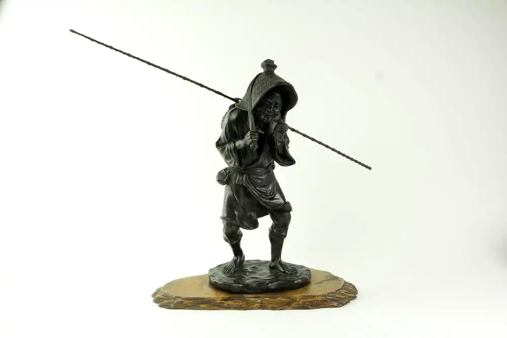 Figur, Japan, Meiji Zeit (1865-1912), Bronze, Fischer mit Strohhut, Bambusangel auf den Schultern und Korb auf dem Rücken, auf Holzsockel, absolut feine Ausformung von höchster Qualität, gemarkt, Gebrauchsspuren, H: 42 cm. 0