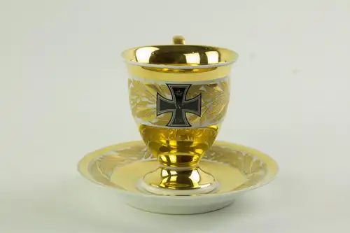 Tasse und Untertasse, gemarkt KMP, Berlin, 1914, umlaufend verziert mit Lorbeerlaub in Goldmalerei, auf Schauseite EK, tadellose Erhaltung. H: 10 cm.  Cup and saucer, marked KPM Berlin, 1914, decorated with bay leaves and EK, very good  condition, H:...