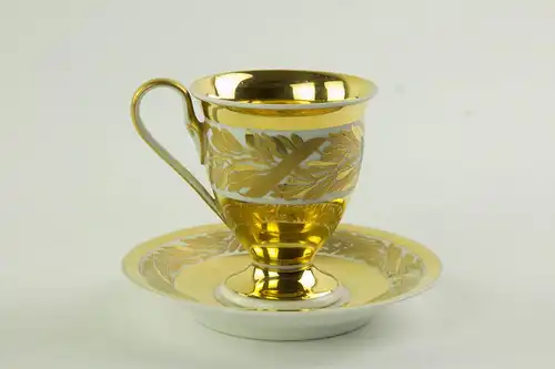 Tasse und Untertasse, gemarkt KMP, Berlin, 1914, umlaufend verziert mit Lorbeerlaub in Goldmalerei, auf Schauseite EK, tadellose Erhaltung. H: 10 cm.  Cup and saucer, marked KPM Berlin, 1914, decorated with bay leaves and EK, very good  condition, H:...