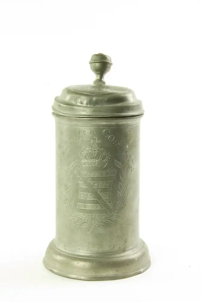 Walzenkrug, um 1800, Zinn, Zinngießer Christian Gotthold Scheffing, auf zylindrischer Wandung das sächsische Wappen im Lorbeerkranz, Ite Schützen Companie, auf Deckel G.M. Schopau 1801, Krug etwas deformiert. H: 25 cm. 0