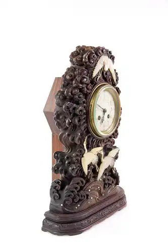 Seltene Uhr, Japan, um 1880, mit französischem Uhrwerk, Holzgehäuse fein geschnitzt mit Wellen und Wolken, verziert mit aufgelegten kleinen Permuttkreisen und drei fein geschnitzten Kranichen aus Perlmutt, sehr guter Zustand, ein Kranich...