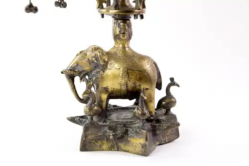 Öllampe, Indien, Anf. 20. Jh., Bronze, in Form eines Lebensbaumes, stehender Elefant auf sternförmigen Sockel, auf drei Etagen je 6 herausnehmbare, mit Pfauen verzierte Elementen deren Ende sich ein  Ölschälchen befindet, , sehr aufwendige und...