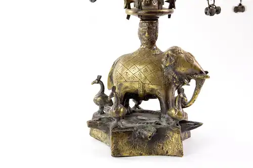 Öllampe, Indien, Anf. 20. Jh., Bronze, in Form eines Lebensbaumes, stehender Elefant auf sternförmigen Sockel, auf drei Etagen je 6 herausnehmbare, mit Pfauen verzierte Elementen deren Ende sich ein  Ölschälchen befindet, , sehr aufwendige und...