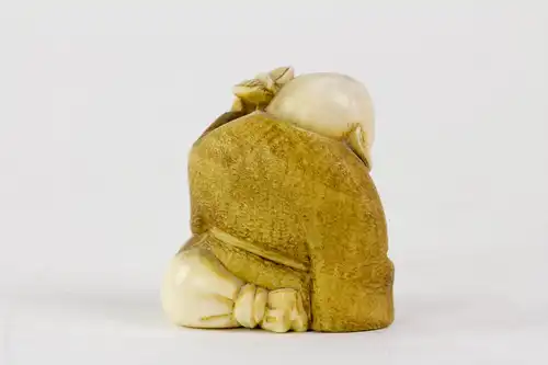 Netsuke, Japan, Meiji-Zeit, um 1900, Elfenbein Buddha mit Palmwedel, fein geschnitzt und signiert, Gebrauchsspuren. H: 3,5 cm.