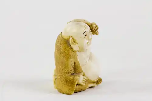 Netsuke, Japan, Meiji-Zeit, um 1900, Elfenbein Buddha mit Palmwedel, fein geschnitzt und signiert, Gebrauchsspuren. H: 3,5 cm.