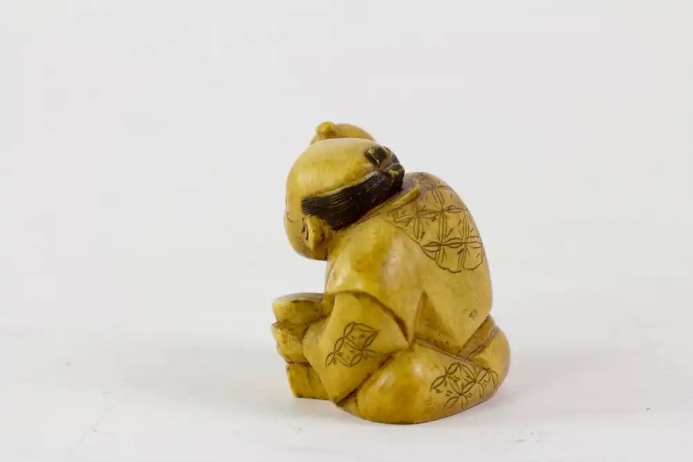 Netsuke, Japan, Meiji Zeit, um 1900, signiert, Elfenbein, sitzender Mann mit Flaschenkürbis und Schale, Gebrauchsspuren. H: 3,5 cm. 2
