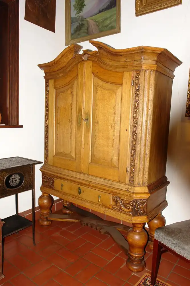 Stollenschrank, Barock, 2. Hälfte 18. Jh., norddeutsch, Eiche massiv, Korpus auf gedrechselten Säulen mit geschwungener Kreuzverstrebung, zweitürig, darunter zentrales Schubfach, Schubfach flankiert von zwei geschnitzten, geflügelten Löwen, neben... 1