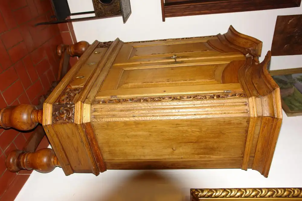 Stollenschrank, Barock, 2. Hälfte 18. Jh., norddeutsch, Eiche massiv, Korpus auf gedrechselten Säulen mit geschwungener Kreuzverstrebung, zweitürig, darunter zentrales Schubfach, Schubfach flankiert von zwei geschnitzten, geflügelten Löwen, neben... 4