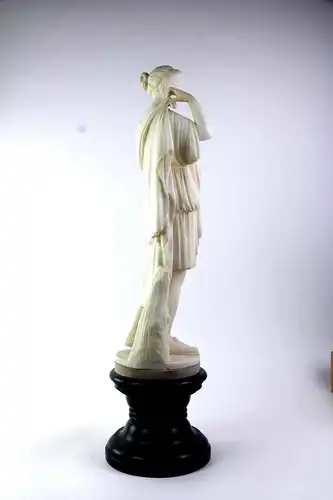 Große Figur, 19. Jh., Italien, Alabaster, Dame im klassisch-antiken Stil mit Gewand vor Baumstamm, wohl Kopie eines Originals, Sockel aus grünen, gedrechselten Marmor, Podest zweiteilig, drehbar, unbeschädigt, Gebrauchsspuren. H: 72 cm.