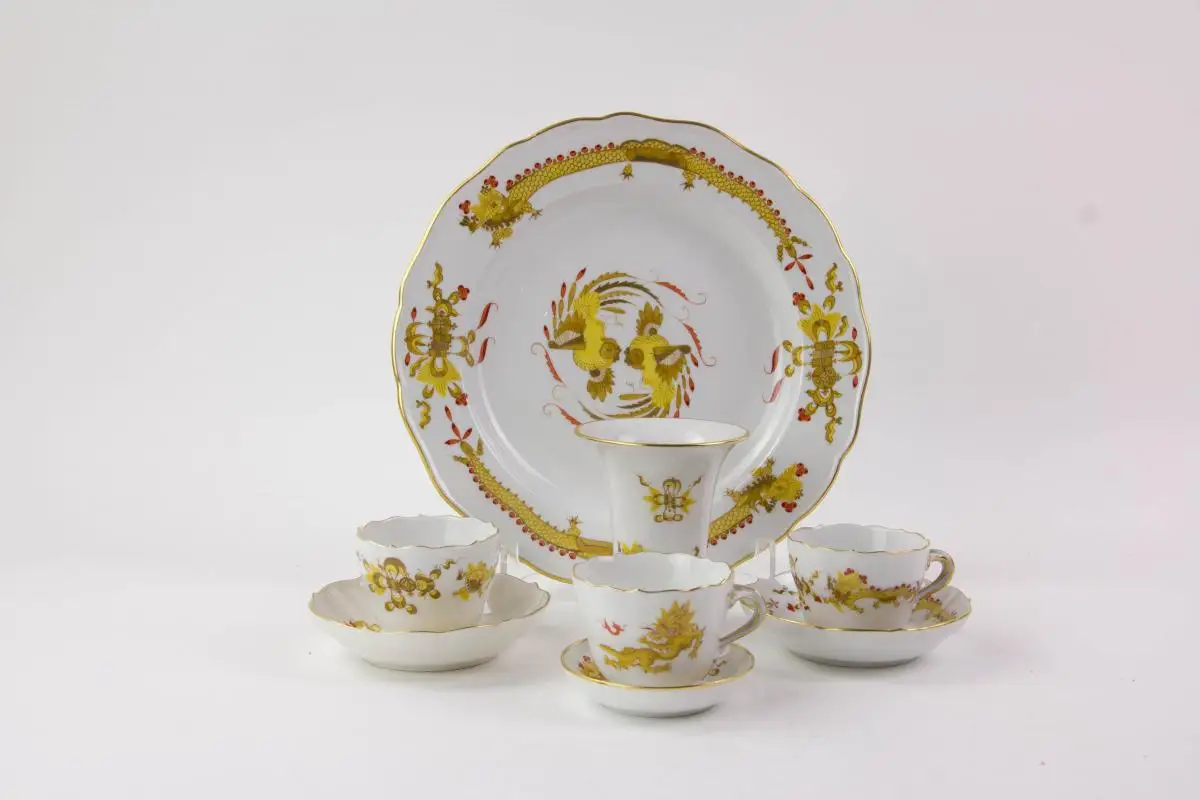 Konvolut Meißner Porzellan, gemarkt Meißen, verschiedene Schwertermarken, 1. Wahl, meist 20er Jahre, gelber Hofdrache, bestehend aus Teller, 3 Moccatassen und Vase, unbeschädigt. Teller D: 25 cm, Moccatassen H: 6 cm, Vase H: 10 cm. 0