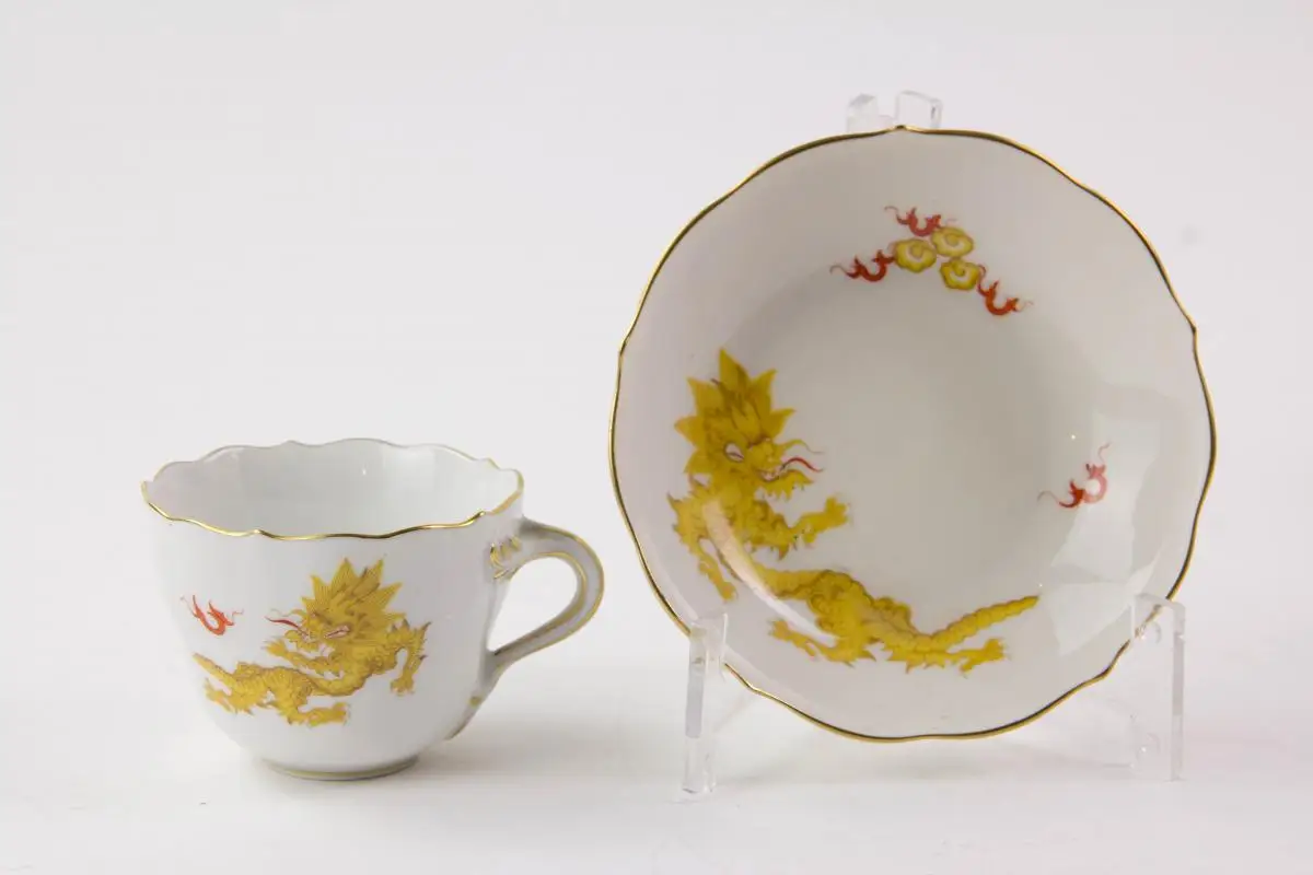 Konvolut Meißner Porzellan, gemarkt Meißen, verschiedene Schwertermarken, 1. Wahl, meist 20er Jahre, gelber Hofdrache, bestehend aus Teller, 3 Moccatassen und Vase, unbeschädigt. Teller D: 25 cm, Moccatassen H: 6 cm, Vase H: 10 cm. 7
