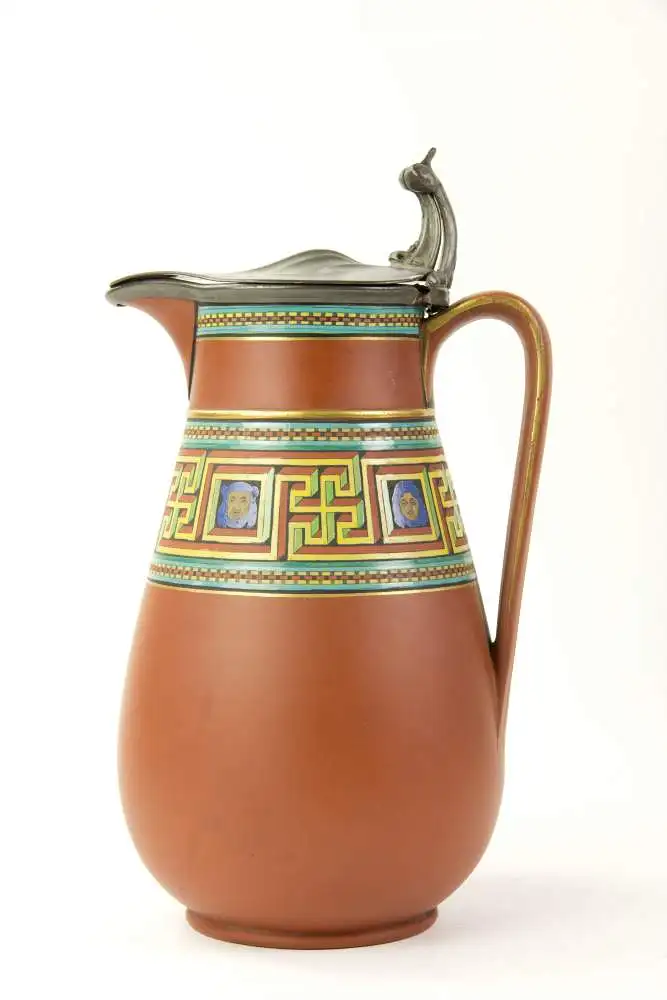 Birnkrug, um 1900, gemarkt Atkin Brothers, Sheffield, rote Keramik, umlaufend polychrome und goldene Bemalung im griechischen, antiken Stil, mit Zinndeckel, dieser defekt, Gebrauchsspuren. H: 22 cm. 0