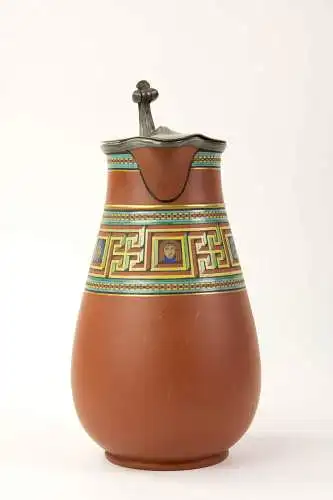 Birnkrug, um 1900, gemarkt Atkin Brothers, Sheffield, rote Keramik, umlaufend polychrome und goldene Bemalung im griechischen, antiken Stil, mit Zinndeckel, dieser defekt, Gebrauchsspuren. H: 22 cm.