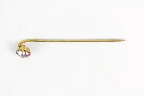 Krawattennadel, um 1900, vergoldet, besetzt mit einem Funkelstein, Gebrauchsspuren. L: 5,8 cm.