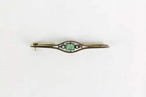 Anstecknadel, um 1910, Jugendstil, gestempelt, Wien, 585er-Rotgold, in der Mitte ein Smaragd in Kissenschliff (5x 3 mm), flankiert von 2 kleinen Diamanten im Rosenschliff, Gebrauchsspuren, L: 4,2 cm, 1,8 g.