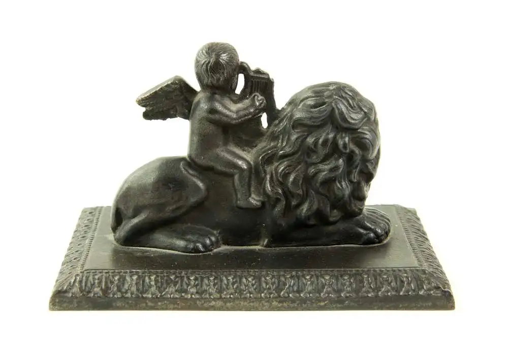 Briefbeschwerer, Anf. 19. Jh., Berliner Eisen, Putto mit Harfe auf Löwe sitzend, auf rechteckiger Grundplatte montiert, Harfe beschädigt, Gebrauchsspuren, L: 13 cm, H: 8 cm. 1