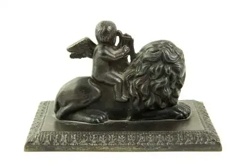 Briefbeschwerer, Anf. 19. Jh., Berliner Eisen, Putto mit Harfe auf Löwe sitzend, auf rechteckiger Grundplatte montiert, Harfe beschädigt, Gebrauchsspuren, L: 13 cm, H: 8 cm.