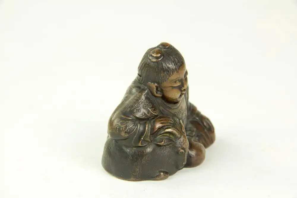 Figur, Japan, 19./20. Jh., Bronze, OKIMONO (jap. 置物, wörtlich: „Hinstellding“, typisch japanische Kunstschnitzarbeiten aus der Zeit der Meiji-Periode), Kind, das Zeige streichelt, Gebrauchsspuren, H: 5 cm. 1