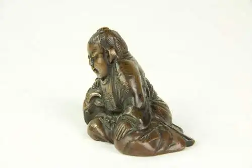 Figur, Japan, 19./20. Jh., Bronze, OKIMONO (jap. 置物, wörtlich: „Hinstellding“, typisch japanische Kunstschnitzarbeiten aus der Zeit der Meiji-Periode), Kind, das Zeige streichelt, Gebrauchsspuren, H: 5 cm.