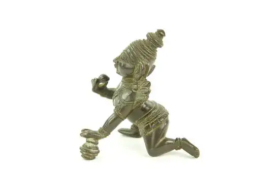 Krishna - Figur, Indien, 19./20. Jh., Bronze, Krishna kniend und Hand auf Butterkugel, Gebrauchsspuren. H: 8 cm.