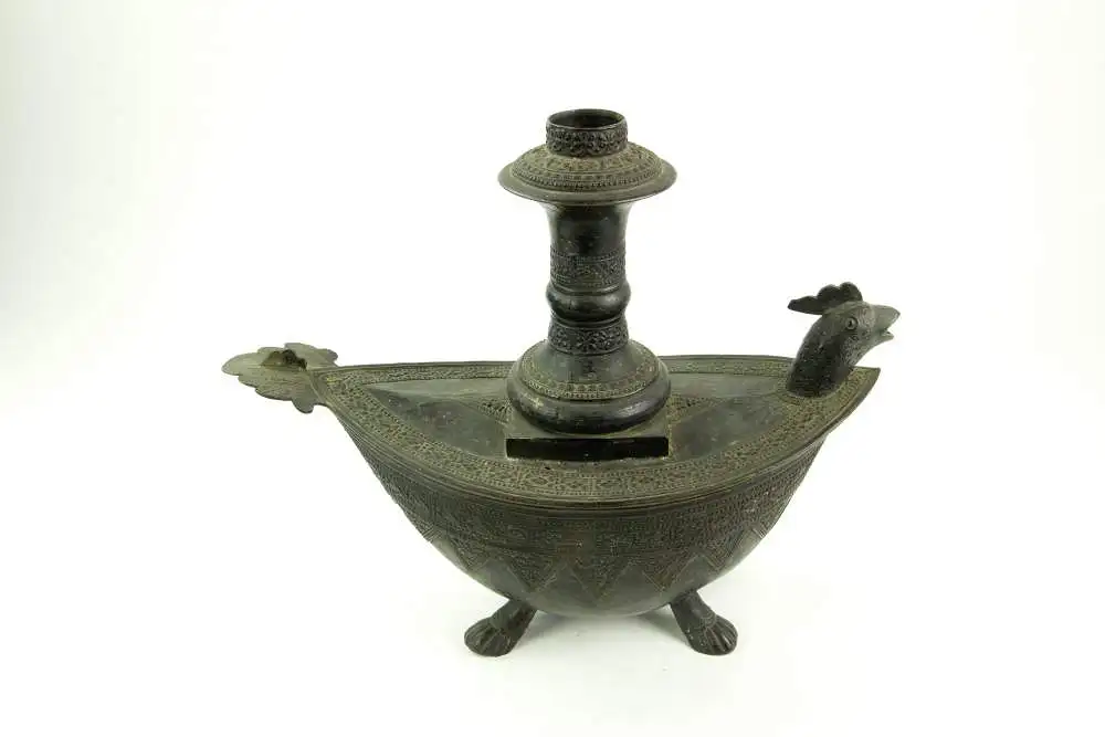 Kendi, Indonesien/Sumatra, 19. Jh., Bronze, mit Ornamenten verziert, in Form eines Schiffes auf Tierfüßen, Ausguss als Vogelkopf gearbeitet, Gebrauchsspuren, guter Zustand. L: 28,5 cm. 0
