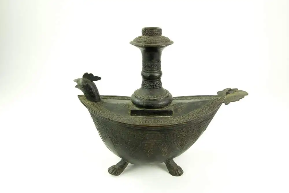 Kendi, Indonesien/Sumatra, 19. Jh., Bronze, mit Ornamenten verziert, in Form eines Schiffes auf Tierfüßen, Ausguss als Vogelkopf gearbeitet, Gebrauchsspuren, guter Zustand. L: 28,5 cm. 1