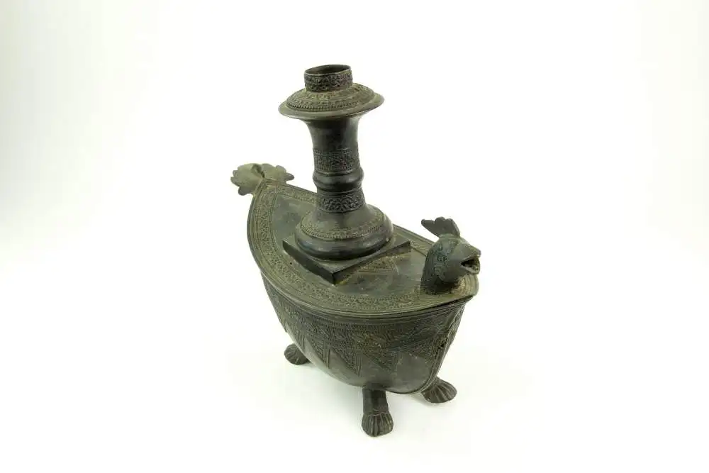 Kendi, Indonesien/Sumatra, 19. Jh., Bronze, mit Ornamenten verziert, in Form eines Schiffes auf Tierfüßen, Ausguss als Vogelkopf gearbeitet, Gebrauchsspuren, guter Zustand. L: 28,5 cm. 2