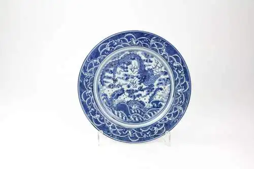 Teller,  China, 19./20. Jh., ungemarkt, im Spiegel mit zwei Drachen in Blaumalerei verziert, Fahne mit Wellen bemalt, leichte Gebrauchsspuren, unbeschädigt, D: 23 cm.