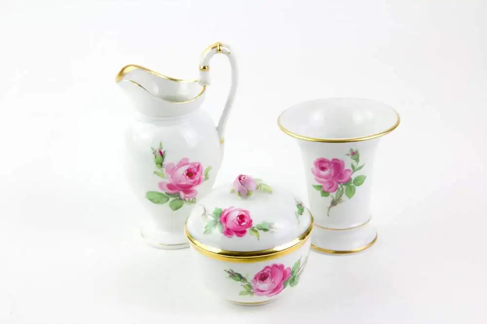 Service, 2. Hälfte 19. Jh., gemarkt Meißen, mit Rosen bemalt, goldverziert, Tassen mit bauchiger Form und hochgezogenem Henkel mit Schwanenkopf, 6-teilig, Kaffeekanne, Sahnekännchen, Zuckerdose mit Rosenknospe als Knauf, Vase, unbeschädigt. 1