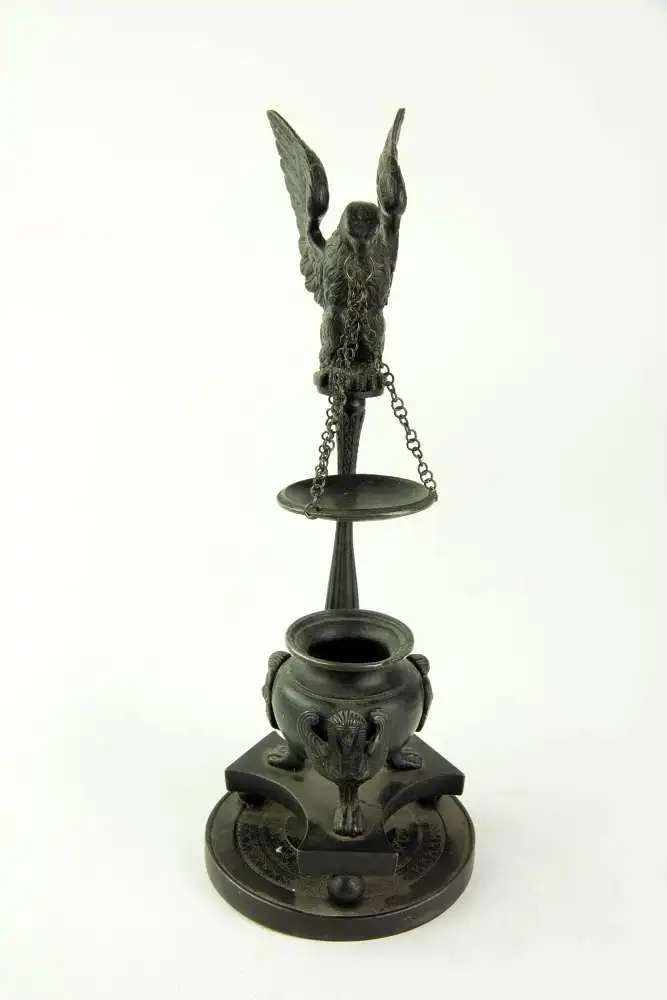 Duftlampe, deutsch, frühes 19. Jh., Berliner Eisen, gefäßförmiger Brenner mit 3 Sphinxen verziert, auf dreipassigen Sockel, runde, mit Ornamenten verzierte Grundplatte, kannelierte Säule mit plastischen Adler bekrönt, der Räucherschale an... 1
