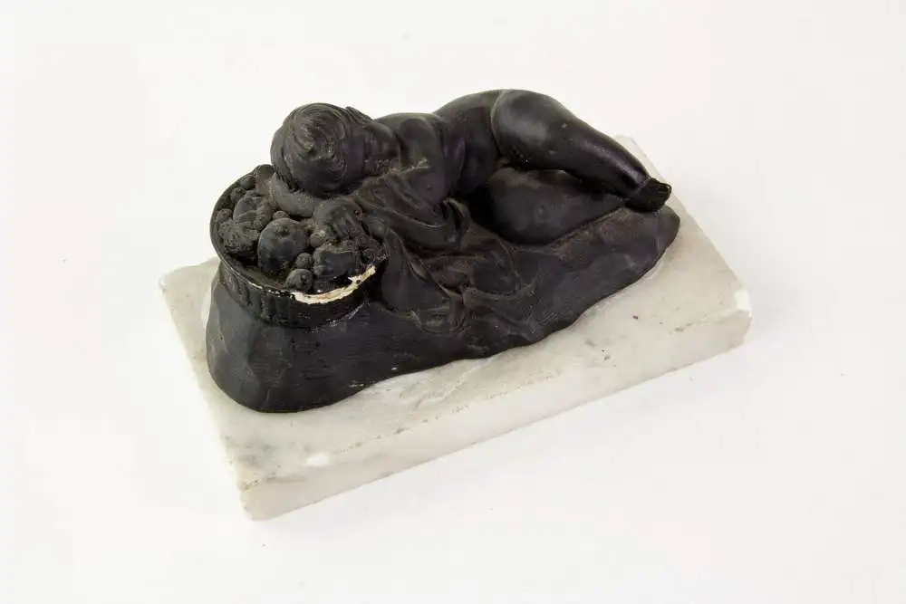 2 Figuren, 19. Jh., Wedgewood, Black Basalt, 2 schlafende Kinder, auf weißem Marmorsockel befestigt (geklebt), eine Figur mit stärkeren Beschädigungen und Restaurierungen, H: 6 cm, L: 14 cm. 5