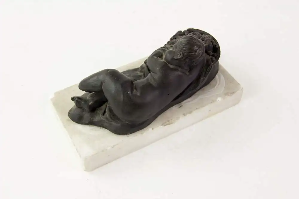 2 Figuren, 19. Jh., Wedgewood, Black Basalt, 2 schlafende Kinder, auf weißem Marmorsockel befestigt (geklebt), eine Figur mit stärkeren Beschädigungen und Restaurierungen, H: 6 cm, L: 14 cm. 6