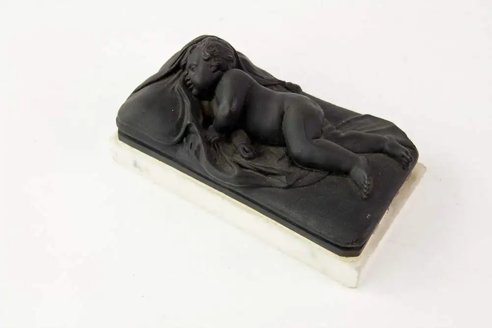 2 Figuren, 19. Jh., Wedgewood, Black Basalt, 2 schlafende Kinder, auf weißem Marmorsockel befestigt (geklebt), eine Figur mit stärkeren Beschädigungen und Restaurierungen, H: 6 cm, L: 14 cm. 7