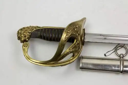 Säbel, Frankreich, M 1923, Säbel für höhere Offiziere, vergoldeter Bronzegefäß mit Löwenkopfabschluss, ausgebrochener  Horngriff, Klinge graviert: Couleaux et Cie à Klingenthal,vernickelte Scheide, ca. 14 cm zu lang, Gebrauchsspuren. L: 104 cm.