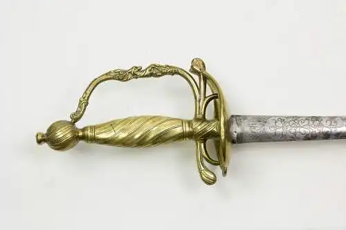 Degen, zweite Hälfte 18. Jh., Gefäß Bronze vergoldet, mit Wellenverzierungen, Griffbügel mittig mit plastischen Hirsch, rhombisch auslaufende Klinge mit Zierätzungen, Griffbügel alt repariert, Gebrauchsspuren. L: 92 cm.