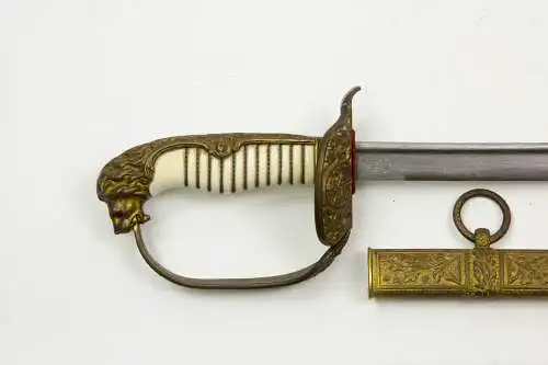 Marine-Säbel, Deutschland, Anf. 20. Jh., vergoldetes Bügelgefäß mit Löwenkopfabschluss, Augen aus zwei Glassteinen in rot (Backbord) und grün (Steuerbord), ausgesuchter Elfeneingriff mit Drahtwicklung, Gefäß mit zwei Klappscharnieren und...