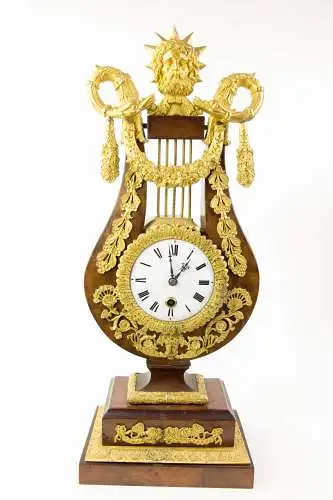 Prunk-Pendule, Anf. 19. Jh., in Form einer Lyra auf Sockel, Mahagoni furniert, reich mit feuervergoldeten Beschlägen verziert, Abschluss David mit Zackenkrone (biblischer König David), flankiert von 2 Schlangen, Email-Ziffernblatt, Fadenaufhängung...