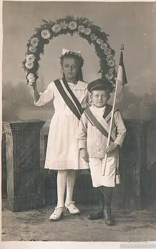 AK Mädchen und Junge in Matrosenanzug mit Blumenkranz & Fahne, Postkarte