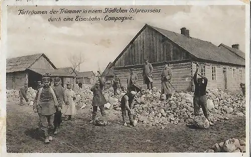 AK Forträumen der Trümmer in einem Städtchen Ostpreussens durch eine Eisenbahn