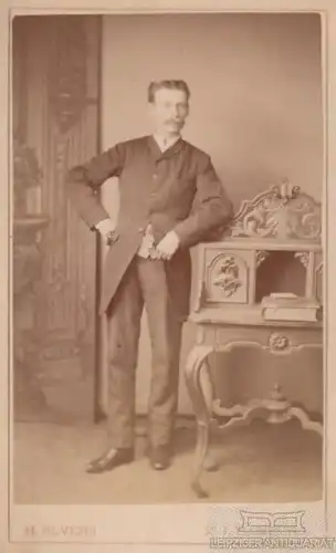 Portrait Herr im Anzug an Kommode lehnend, Fotografie. Fotobild, ca. 1887