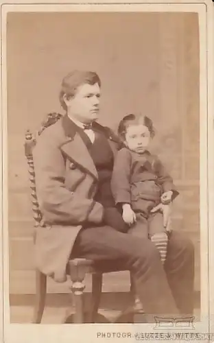 Portrait bürgerlicher Herr auf Stuhl sitzend mit Kind auf dem Schoß, Fotografie